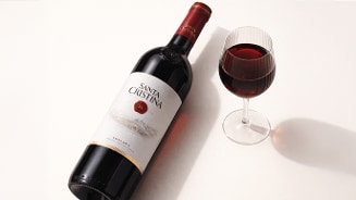 Fles Santa Cristina Toscaanse rode wijn naast een gevuld wijnglas