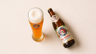 Paulaner Hefe-Weißbier fles en een bijpassend glas gevuld met witbier