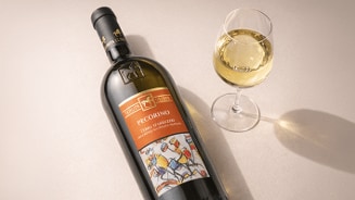 Fles witte wijn van het merk Tenuta Ulisse Pecorino Terre di Chieti met een gevuld wijnglas ernaast.
