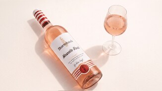 Fles Stormhoek Moscato Rosé met een glas roséwijn op een lichte ondergrond.