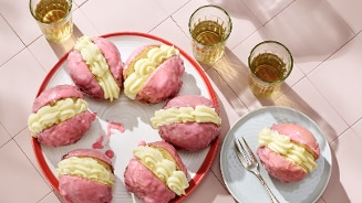 Tompouce oliebollen op een bord met roze achtergrond