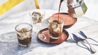 Italiaanse affogato met espresso uit een Bialetti percolator, geserveerd op een terras met een gele stoel.