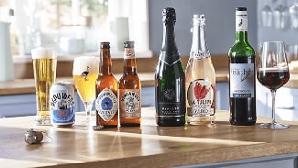 Assortiment van alcoholvrije dranken op een tafel, inclusief Brouwers 0.0, Lowlander Wit 0.00%, Vivera Sparkling, La Tulipe Zero en The Feather Merlot.
