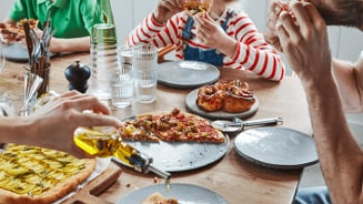 Vriendengroep geniet samen van pizza aan tafel