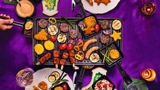 Gourmet arrangement met diverse groenten en vlees op een tafel met een paarse tafelkleed.