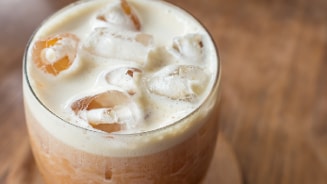 Kopje cappuccino op een houten tafel