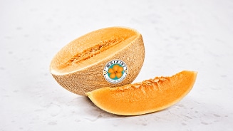 Een halve Waikiki meloen en een meloenpartje op een lichte achtergrond.