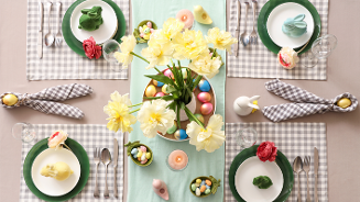 Gedekte Paastafel met vrolijk, gekleurde Paasdecoratie