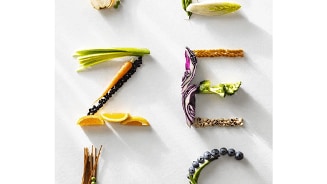 Groenten en fruit in de vorm van het woord "VERS" op een lichte achtergrond.