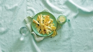 Witte asperges met saus en broodkruim