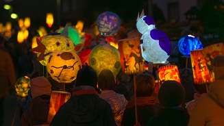 Kinderen lopen 's avonds buiten met zelfgemaakte kleurrijke lampionnen tijdens een lampionoptocht