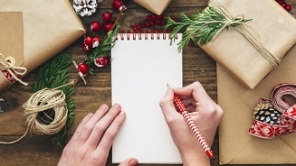 Cadeaulijst maken tijdens kerstvoorbereidingen met cadeaus en kerstdecoraties.
