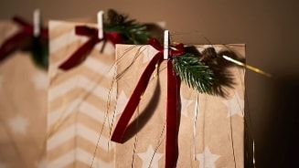 Kerstcadeauzak met sterpatroon en rode lintdecoratie