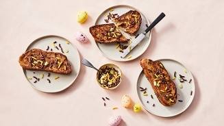 Pasta met paasbrood en paasdecoratie op borden, omringd door paaseieren.