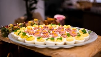 Gevulde eieren op een grote schaal, gegarneerd met kruiden en groente, geschikt als hapjes voor een buffet of feest.