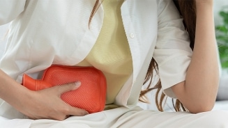 Vrouw met kruik tegen haar buik