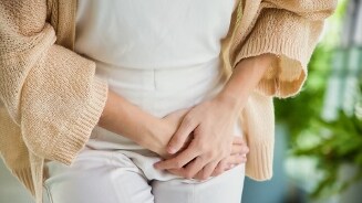 Vrouw die buik vasthoudt in een ongemakkelijke pose