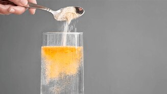 Lepel poeder wordt toegevoegd aan een glas water