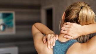 Vrouw die haar nek strekt met haar handen.