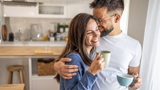 Twee mensen die samen in een keuken staan en koffie drinken