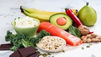 Verschillende etenswaren die aminozuren bevatten zoals avocado, zalm, rijst, havermout, peer, peper, noten en chochola.