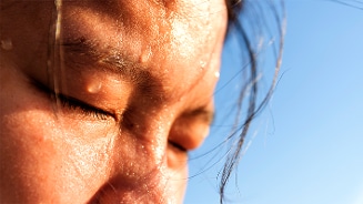 Nauwkeurige weergave van een gezicht in close-up met de heldere blauwe lucht op de achtergrond.