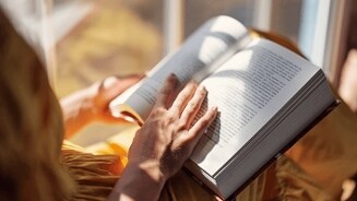 Persoon leest een boek in zonlicht