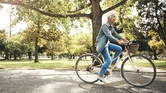 Persoon fietst in een park op een zonnige dag