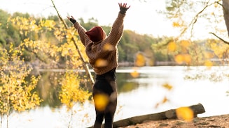 Persoon in herfstlandschap bij een meer