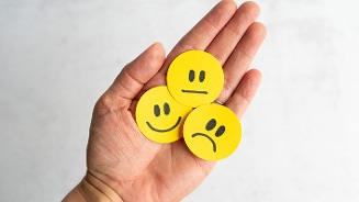 Gele smileys met verschillende gezichten op een hand