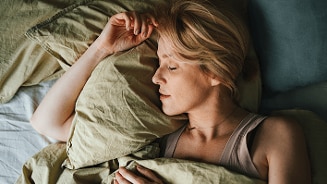 Vrouw in bed onder groene dekens