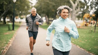 Twee personen joggen in een park.