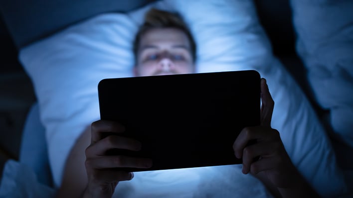 Persoon leest op een tablet in bed