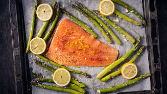 Zalmfilet met asperges en schijfjes citroen op een bakplaat