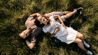 Twee mensen liggend in het gras tijdens een zomerse dag