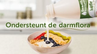 Kefir van Beautifulimmunity wordt over een ontbijtkom met fruit en granola gegoten, met de tekst "Ondersteunt de darmflora".