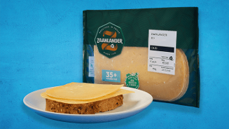 Plakjes Zaandlander 35+ oude kaas op een snee volkorenbrood op een wit bord, met een verpakking Zaandlander kaas op de achtergrond.