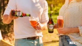 Twee mensen die Grolsch Radler 0.0% bier inschenken in glazen, met NIX18 logo zichtbaar.
