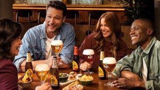 Stel vrienden in een kroeg die verschillende Leffe speciaalbieren drinken