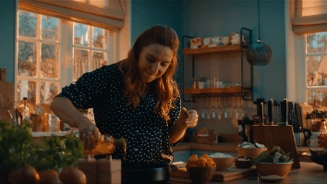 Persoon koken in een moderne keuken met verse ingrediënten op het aanrecht.