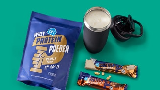 AH Whey proteïnepoeder en proteïnerepen met een shakebeker op een groene achtergrond.