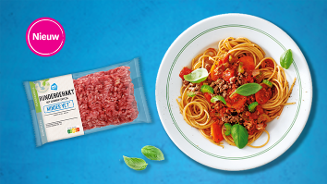 Nieuw Albert Heijn rundergehakt minder vet naast een bord spaghetti bolognese met verse basilicum.