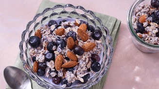 Havermout ontbijt met blauwe bessen en amandelen in een glazen kom