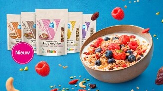 Ontbijtgranen van Albert Heijn in verschillende smaken op een rij, met vooraan een kom yoghurt met ontbijtgranen, aardbeien, frambozen en blauwe bessen. Links een label met de tekst "Nieuw".