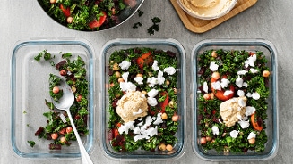 Maaltijdprep: Gezonde en kleurrijke salades in bewaardozen met hummus en geitenkaas.
