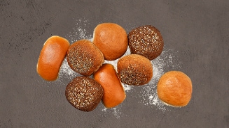 Verschillende soorten broodjes op een tafel met meel.