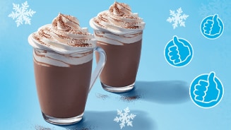 Twee glazen warme chocolademelk met slagroom, versierd met cacaopoeder, op een blauwe achtergrond met sneeuwvlokken en blauwe duimen iconen.