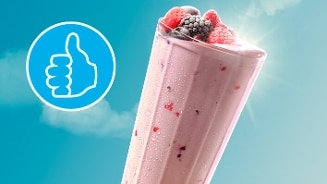 Smoothie met gemengde bessen en een duim omhoog-icoon op een zonnige blauwe achtergrond.