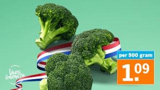 Drie verse broccoli's met een rood-wit-blauwe lint en prijskaartje van €1,09 per 500 gram, met het Vers Garantie logo van Albert Heijn.