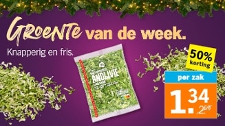 Promotieafbeelding van de Albert Heijn groente van de week: gesneden andijvie in een AH-verpakking, met 50% korting voor 1,34 euro per zak, op een paarse achtergrond met kerstverlichting.